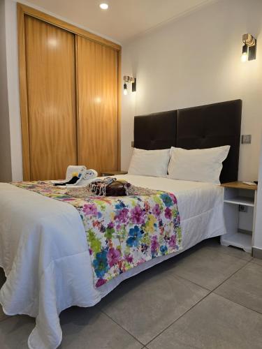 a bedroom with a large bed with a floral blanket at LC's Guesthouse in Lagos