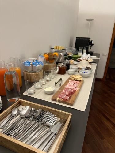 a table with food and utensils on it at Room & Breakfast D'Annunzio in Ravenna
