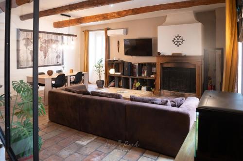 un salon avec un canapé et une cheminée dans l'établissement Maison atypique, grande terrasse avec jacuzzi, à Cazouls-d Herault