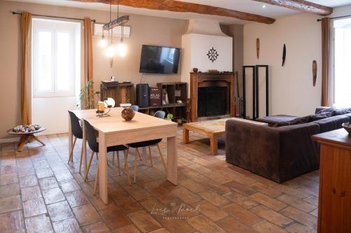 un salon avec une table et un canapé dans l'établissement Maison atypique, grande terrasse avec jacuzzi, à Cazouls-d Herault