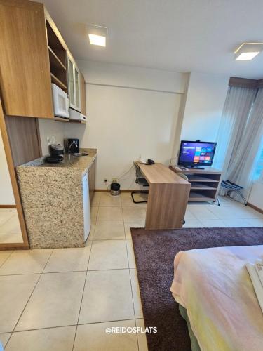a room with a kitchen and a desk with a computer at Flat Saint Moritz Express By Rei dos Flats in Brasilia