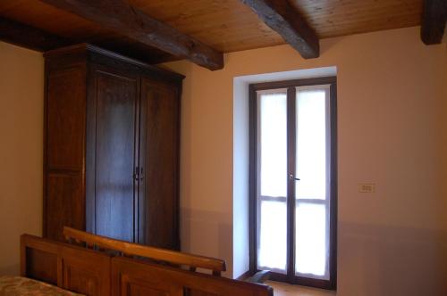 a bedroom with a large window and a wooden cabinet at Casa del Gelsomino in Varallo