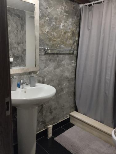 a bathroom with a sink and a shower curtain at Studio47 in Athens