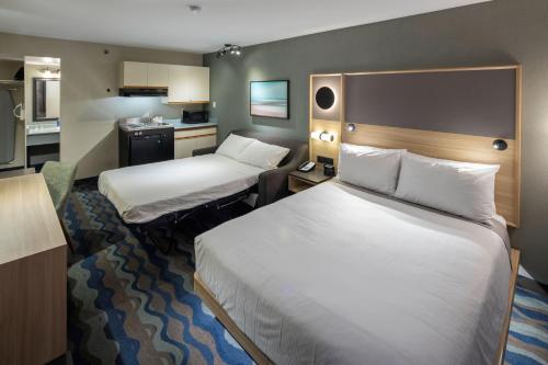 una camera d'albergo con due letti e una cucina di Accent Inns Vancouver Airport a Richmond