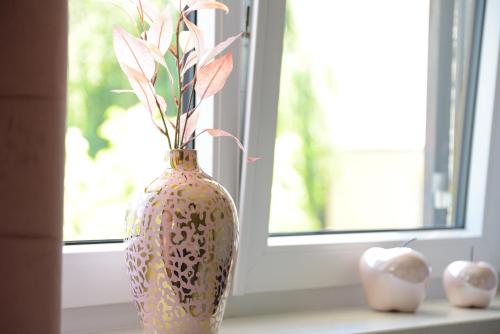 a vase with flowers in it sitting on a window sill at UNiQE I Stilvolle 115qm I Terrasse I BBQ in Feldafing