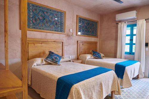 a room with two beds and a window at Hotel Mansión Chiapa in Chiapa de Corzo