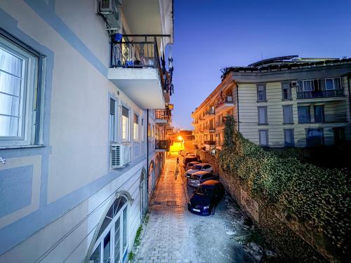 a narrow alley with cars parked next to buildings at Marina Apartment - The Ocean Heart of Shkodra in Shkodër