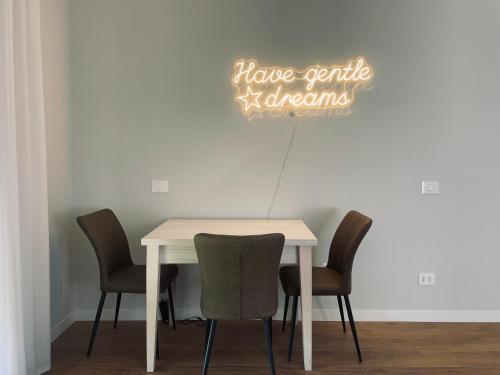 un tavolo con sedie e un cartello con la scritta "avete un dolce asilo" di B&b Comfort Home Apartment a Civitavecchia