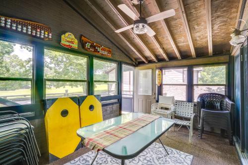a room with a glass table and some windows at 1 Mi to Margaritaville Resort Cottage with Fire Pit in Osage Beach