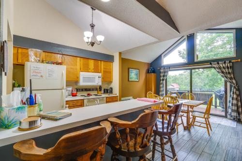 a kitchen with a table and chairs and a refrigerator at 1 Mi to Margaritaville Resort Cottage with Fire Pit in Osage Beach
