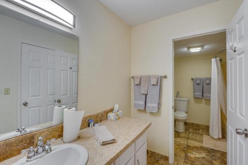 a bathroom with a sink and a toilet and a mirror at 1 Mi to Margaritaville Resort Cottage with Fire Pit in Osage Beach