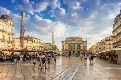 Un gruppo di persone che camminano in una piazza della città di Magnifique Loft sur 2 niveaux Comédie Gare a Montpellier