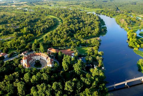 an aerial view of a house on the shore of a river at Hotel Zamek Pułtusk Dom Polonii in Pultusk