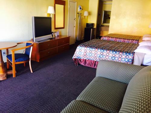 a hotel room with two beds and a flat screen tv at Travelodge by Wyndham New Braunfels in New Braunfels