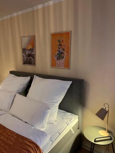 1 dormitorio con 1 cama con sábanas blancas y lámpara en OLIVE Apartments - 3x Kingsize Bedrooms - Free Parking en Hannover