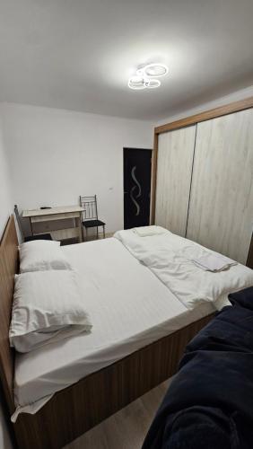 a bedroom with a large bed with white sheets at Casa de la Dunăre-Dăeni in Dăeni