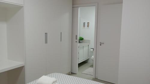 uma casa de banho branca com uma cama e um WC em RED DESIGN - Apto completo 2 Qts 901 em Vitória
