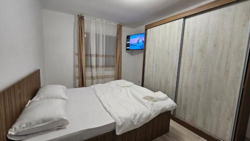 a small bedroom with a bed and a television at Casa de la Dunăre-Dăeni in Dăeni