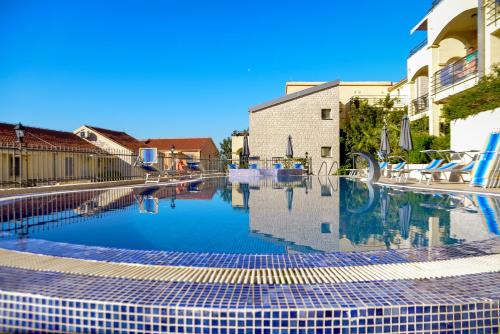 a swimming pool with blue and white tiles on the ground at The Sun & Sea Apartment in Becici