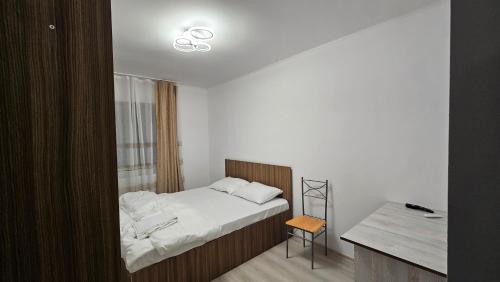 a small bedroom with a bed and a desk at Casa de la Dunăre-Dăeni in Dăeni