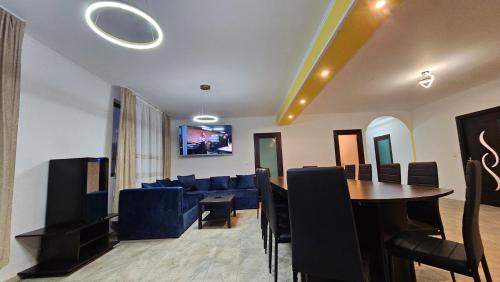 a living room with a table and a blue couch at Casa de la Dunăre-Dăeni in Dăeni