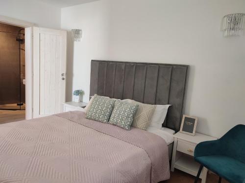 um quarto com uma cama grande e uma cabeceira cinzenta em Luxe chalet 79 em Ruzomberok