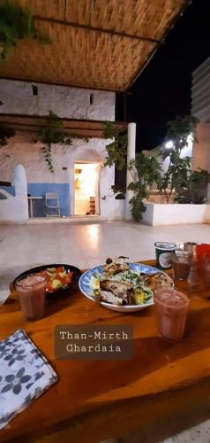 a table with two plates of food on it at Thanmirth Ghardaia in El Ateuf