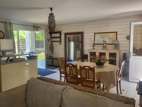 une cuisine et une salle à manger avec une table et des chaises dans l'établissement L'échappée Belle à 5 minutes de la plage, à Fouesnant