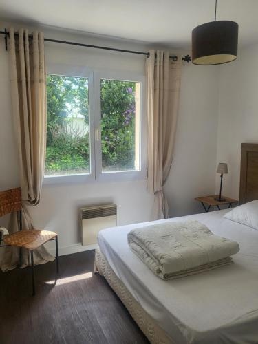 une chambre avec un lit et deux fenêtres dans l'établissement L'échappée Belle à 5 minutes de la plage, à Fouesnant