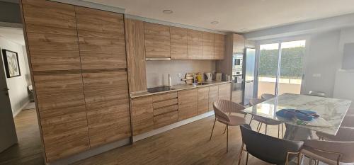 a kitchen with wooden cabinets and a table with chairs at Faro Main Avenue Apartment II in Faro