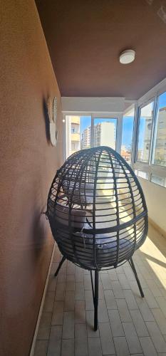 a bird cage sitting in a room with a window at Faro Main Avenue Apartment II in Faro