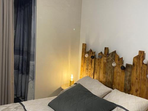 Chambre Coté bassin في أودينج: غرفة نوم مع سرير مع اللوح الأمامي الخشبي