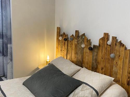 Chambre Coté bassin في أودينج: سرير مع اللوح الخشبي في غرفة النوم
