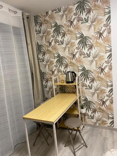Chambre Coté bassin في أودينج: طاولة وكرسي في غرفة مع ورق جدران