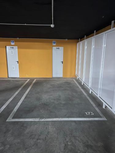 an empty parking lot with three white doors at Espectacular apartamento en Gran cannet in Canet de Berenguer