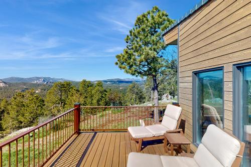 a deck with white chairs and a view of the mountains at Ponca Lode Retreat in Keystone