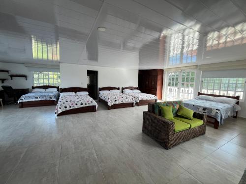 Habitación grande con 4 camas y sofá. en Mirador El paraiso glamping en Villavicencio