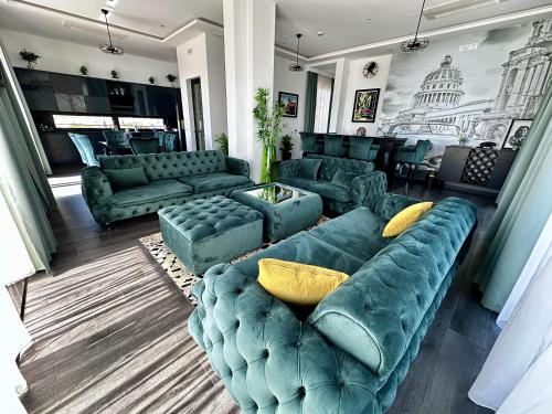 a living room with blue couches and yellow pillows at Hotel Del Medio in Sutomore