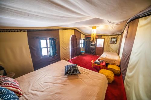 a bedroom with two beds in a tent at Aladdin Desert Camp in El Gouera