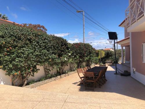 a patio with a table and chairs and some bushes at Grace Villa in Aldeia de Juso