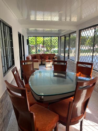 uma sala de jantar com uma mesa de vidro e cadeiras em Mirador El paraiso glamping em Villavicencio