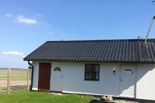 Skåne-TranåsにあるCharming cottage in a beautiful landscapeの黒屋根の小さな白い家