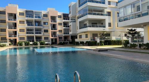 una gran piscina frente a un edificio en Appartement de luxe dans une résidence fermée avec piscine, en Pont Blondin