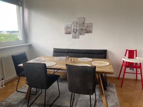 - une salle à manger avec une table et des chaises en bois dans l'établissement TAMLiving Zentrum Luxus Parken Messe WIFI Traumaussicht Sunrise&Sunset, à Graz