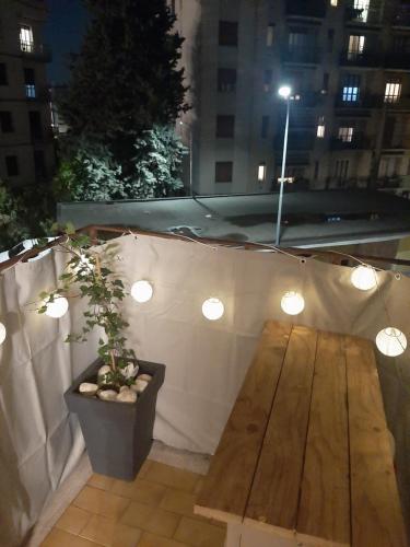 a table and a potted plant on a rooftop at night at Mami home in Cormano