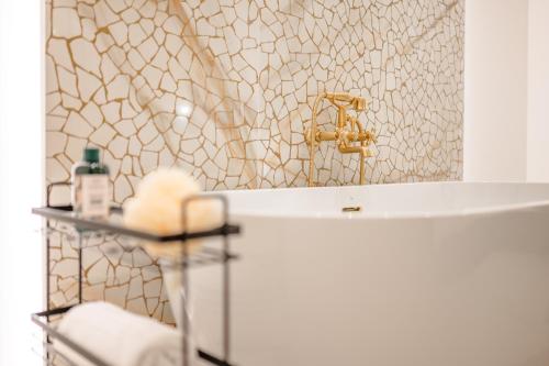 a bathroom with a tub and a gold sink at Capital Hideaway in Valletta