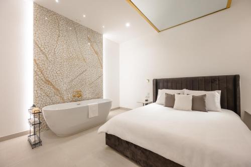 a bedroom with a large bed and a bath tub at Capital Hideaway in Valletta