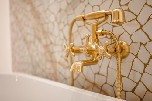 a gold faucet in a bathroom with a mirror at Capital Hideaway in Valletta
