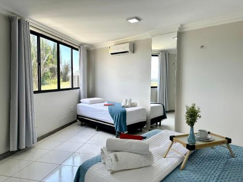 a bedroom with two beds and a couch and a table at (107) Beach Mar e Sol - Perto da Praia in Pimenta