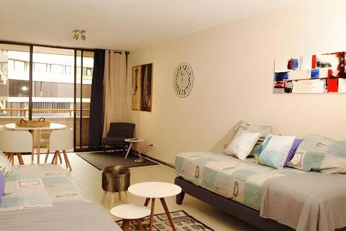 Habitación con 2 camas, mesa y mesa. en Living Paris en Santiago